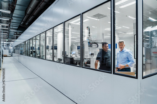 Engineers discussing over laptop in manufacturing industry photo