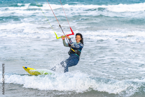 Cheerful woman surfing with kiteboard on water