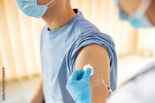 Global vaccination and immunization during covid 19. Close up of nurse s hands putting an injection of covid 19 vaccine into a patient s arm.