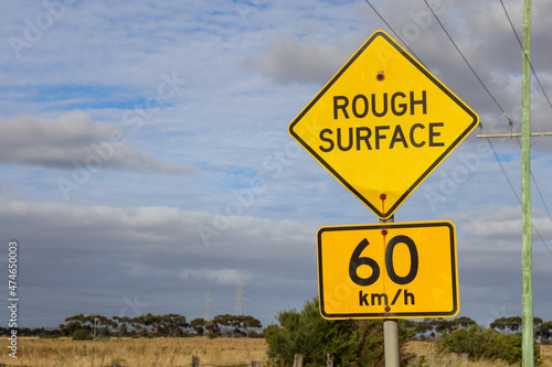 rough surface and speed limit sign on the road against sky