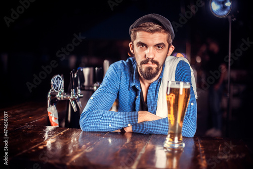 Confident tapster intensely finishes his creation in cocktail bars photo