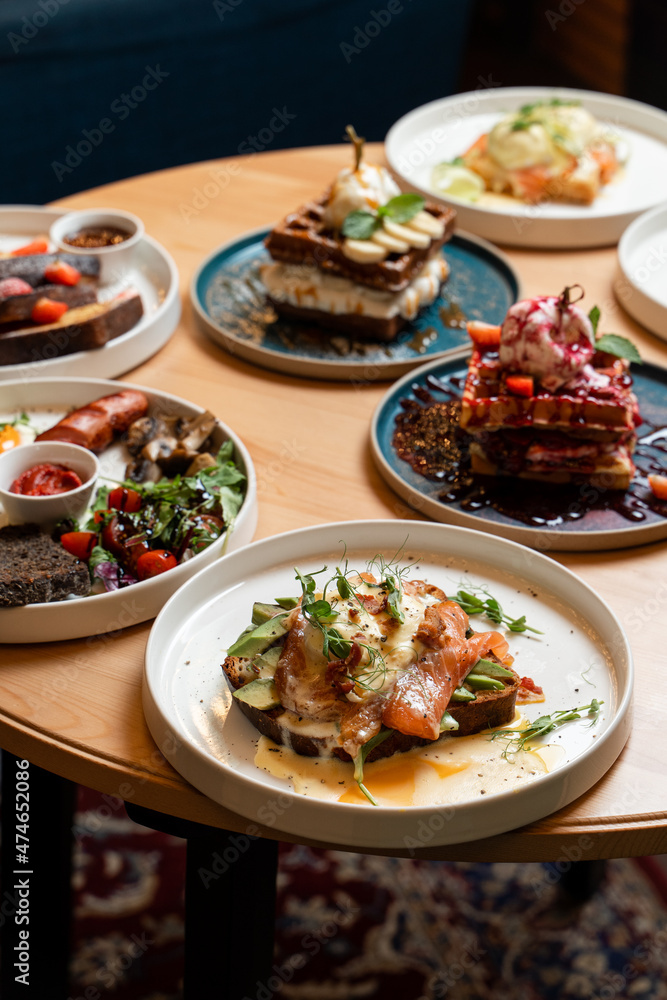 Brunch meals on wooden table, side view of served round table Brunch meals on wooden table, side view of served round table