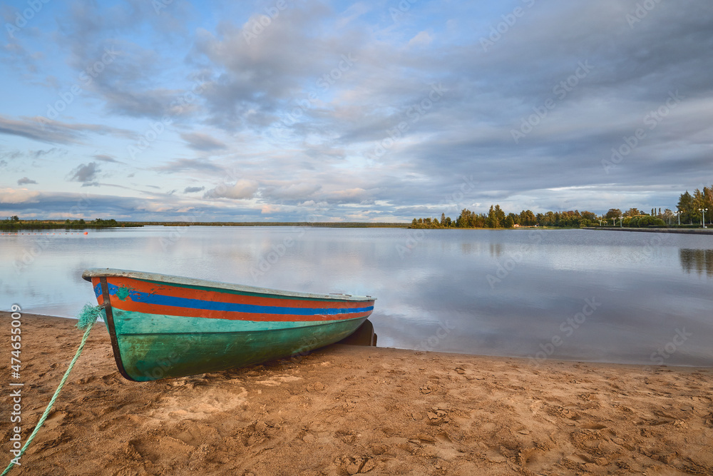 Rescue boat on the shore of the lake in calm summer weather: sandy beach, clouds, Sestroretsky Razliv.