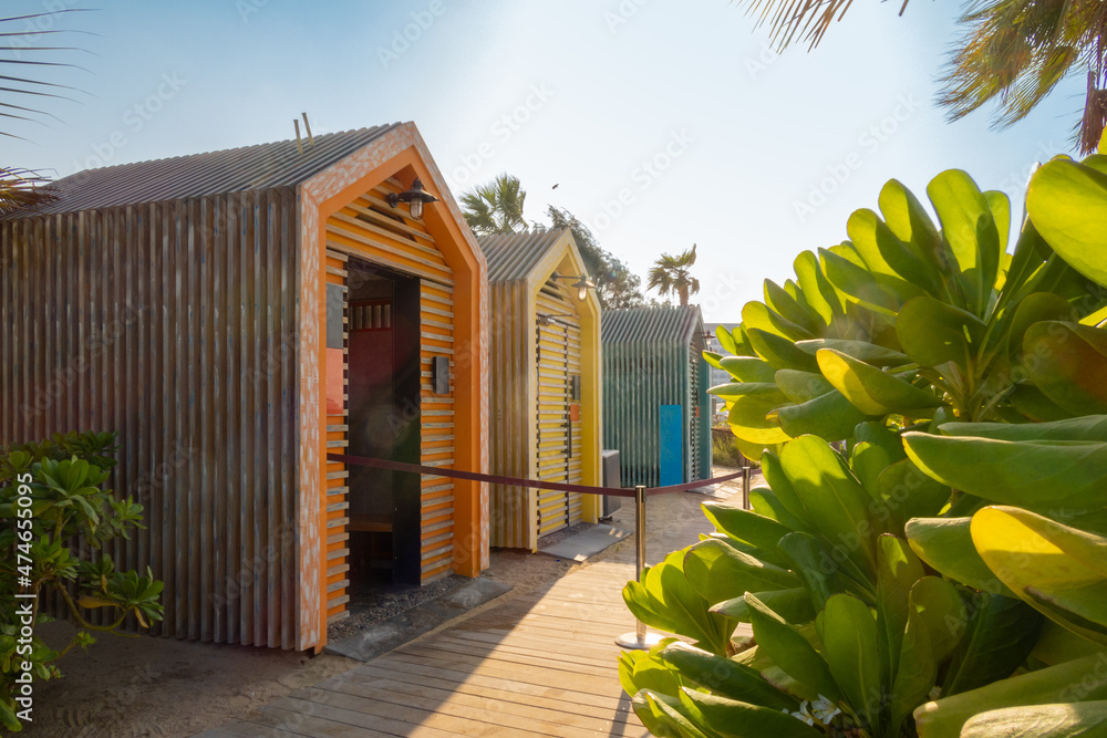 Fototapeta premium Bright colorful wooden houses on beach. Summer vacation at multicolored beach sheds huts. High quality photo