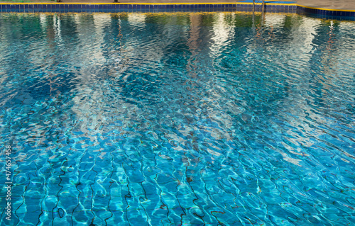 selective focus on the blue surface of the water in the pool with reflections. Relaxing natural background with transparent water