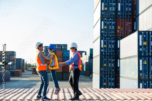 Business heir concept. Grandfather, Father and daughter are standing in Container cargo harbor. They are happy together because of successful into container for loading