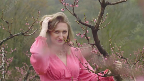 Pink peach orchard during flowering with a young girl