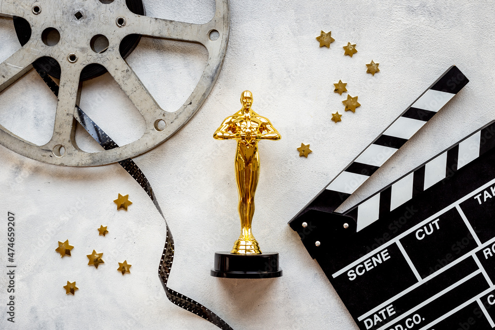 Golden movie award statue with film reel video tape and clapper board ...
