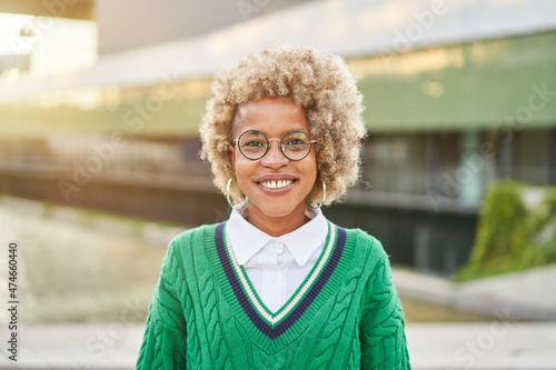 Portrait of a beautiful african woman smiling. Young black female in casual looking at camera with. Cheerful girl with afro hair outdoors.