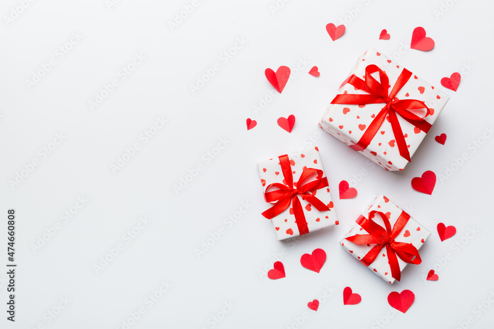 Valentine day composition: red gift box with bow and heart. Christmas present. View from above. Space for text. Holday greeting card Valentine day composition: red gift box with bow and heart. Christmas present. View from above. Space for text. Holday greeting card