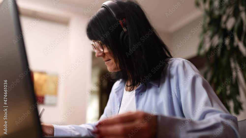 Senior woman student learning language, watching online course, e-learning education, writing notes, Mature old lady wearing headphones, study online education training Senior woman student learning language, watching online course, e-learning education, writing notes, Mature old lady wearing headphones, study online education training
