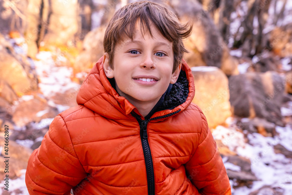 Portrait of a white Caucasian boy 8 years old in a pink jacket in the winter forest in the mountains while hiking Portrait of a white Caucasian boy 8 years old in a pink jacket in the winter forest in the mountains while hiking