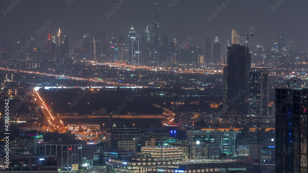 Dubai Downtown skyline row of skyscrapers with tallset tower aerial all night timelapse. UAE