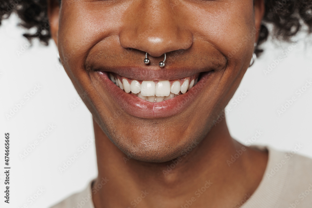 Fototapeta premium Young black man with piercing posing and smiling at camera