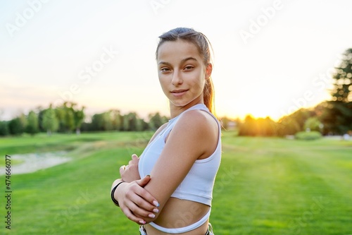 Outdoor portrait of beautiful teenage smiling girl looking at camera.