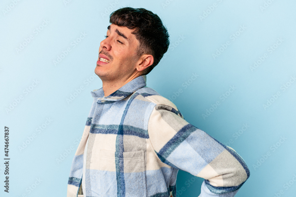 Fototapeta premium Young mixed race man isolated on blue background suffering a back pain.