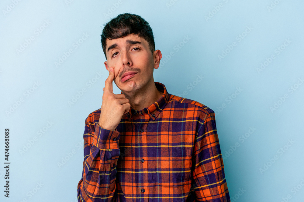 Young mixed race man isolated on blue background crying, unhappy with something, agony and confusion concept. Young mixed race man isolated on blue background crying, unhappy with something, agony and confusion concept.