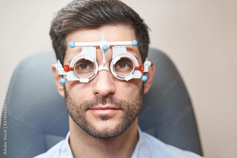 Male in trial frame staring forward at camera Male in trial frame staring forward at camera