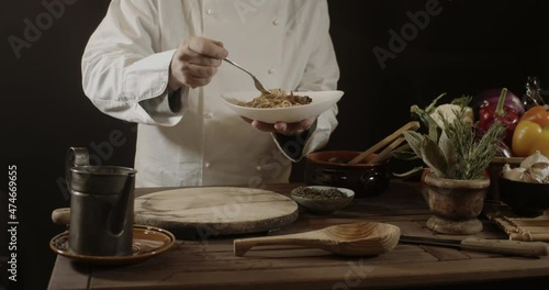 Wallpaper Mural Male chef in white uniform prepares spaghetti with vegetables on the dish using the fork before serving it Torontodigital.ca