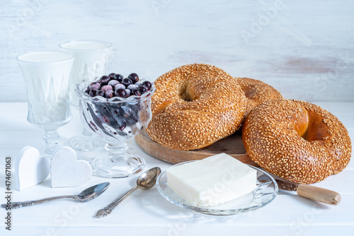 Cuadro en lienzo Food background with fresh bagels, chilled berries, halloumi cheese for simple breakfast on white wooden surface