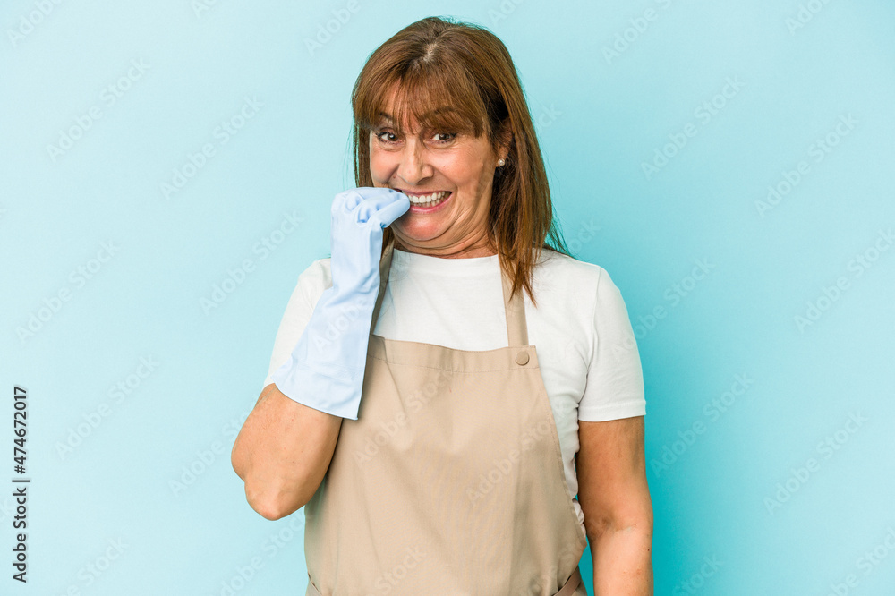 Middle age caucasian woman cleaning home isolated on blue background biting fingernails, nervous and very anxious. Middle age caucasian woman cleaning home isolated on blue background biting fingernails, nervous and very anxious.