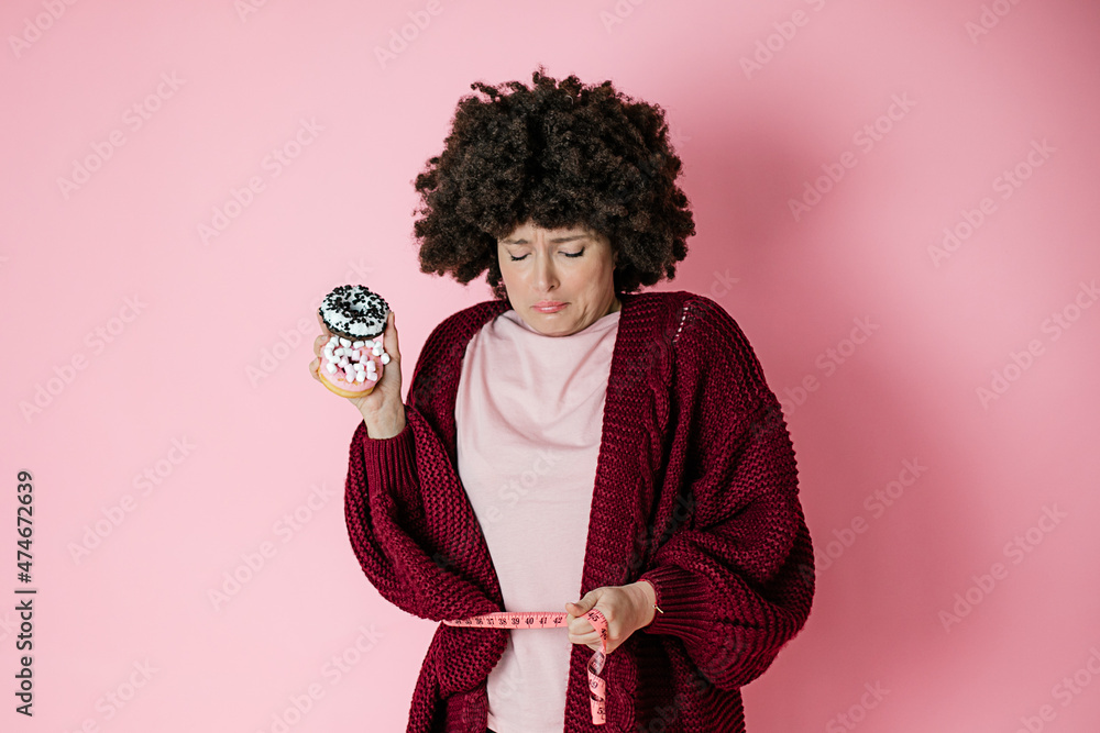 Sweet food donut In female hands. woman is upset. Cannot cope with food addiction to sweets. Sweet food donut In female hands. woman is upset. Cannot cope with food addiction to sweets.