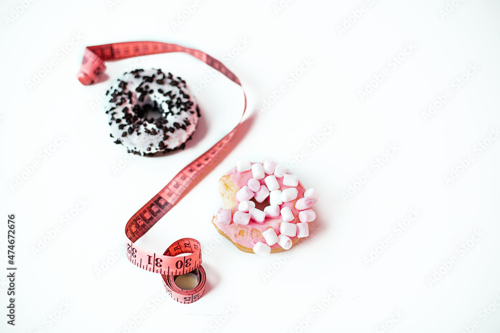 Sweet donut with marshmallow and Tape Measure on white background. Healthy lifestyle and diet concept. Sweet donut with marshmallow and Tape Measure on white background. Healthy lifestyle and diet concept.