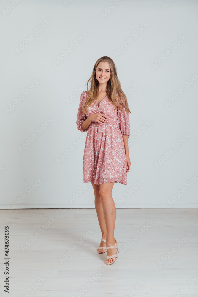 beautiful blonde woman in a light summer pink dress