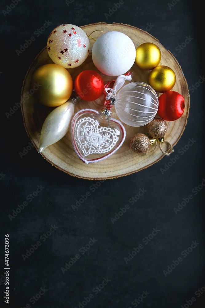Wooden tray with Christmas ornaments in red, gold and white tones. Dark background, flat lay. Wooden tray with Christmas ornaments in red, gold and white tones. Dark background, flat lay.