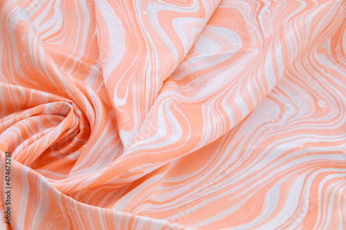 Orange top view of base color silk, fabric with orange marble pattern silk, wavy, spiral, crease, swirl, backdrop, cloth background, have copy space for text