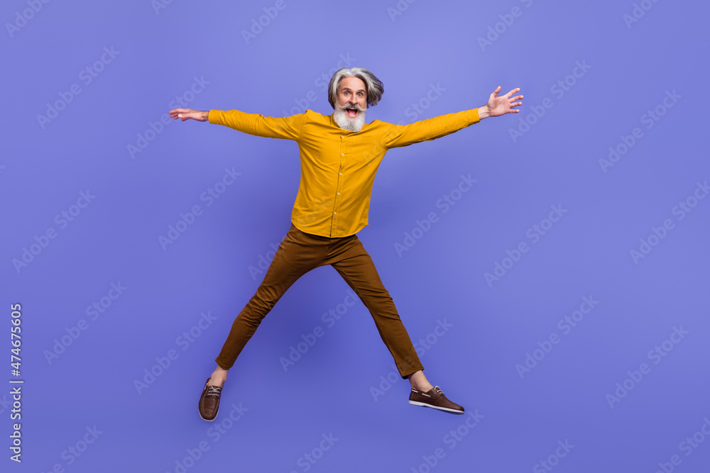 Full length body size view of attractive cheery funny gray-haired man jumping having fun isolated over bright violet purple color background