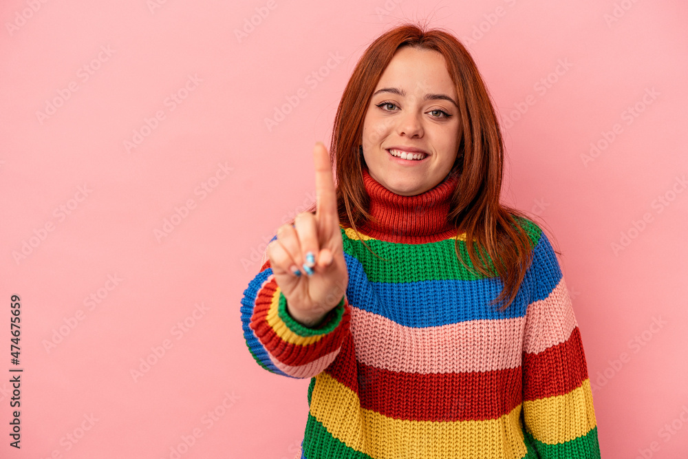 Young caucasian woman isolated on pink background showing number one with finger. Young caucasian woman isolated on pink background showing number one with finger.