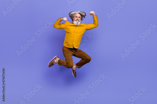Full length body size view of attractive cheery strong gray-haired man jumping striving isolated over bright violet purple color background