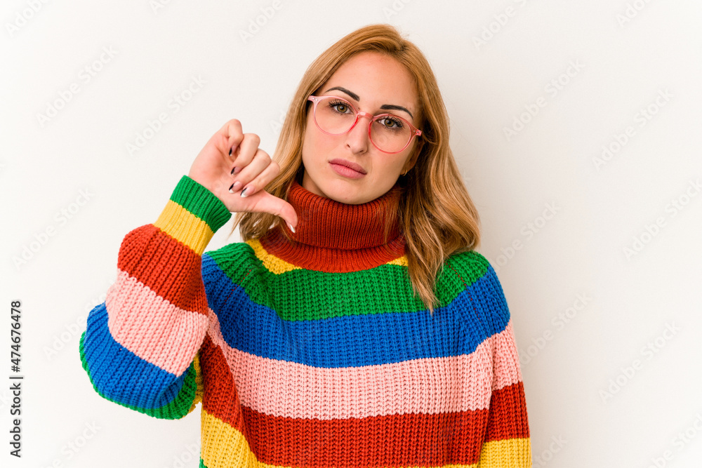Young caucasian woman wearing a sweater with stripes isolated on white background showing a dislike gesture, thumbs down. Disagreement concept. Young caucasian woman wearing a sweater with stripes isolated on white background showing a dislike gesture, thumbs down. Disagreement concept.