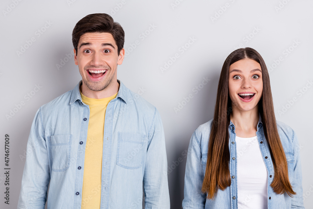 Photo of funny impressed brother sister dressed denim shirts smiling open mouth isolated grey color background Photo of funny impressed brother sister dressed denim shirts smiling open mouth isolated grey color background