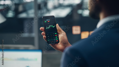 Photography Black Businessman Holding Smartphone and Checking Stock and Cryptocurrency Market in Office