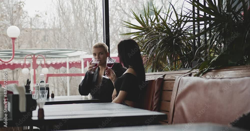 custom made wallpaper toronto digitala romantic date in a restaurant for two representatives of the lgbtq + community. Two young women with glasses of wine at a table in a restaurant chatting with each other in a romantic setting.