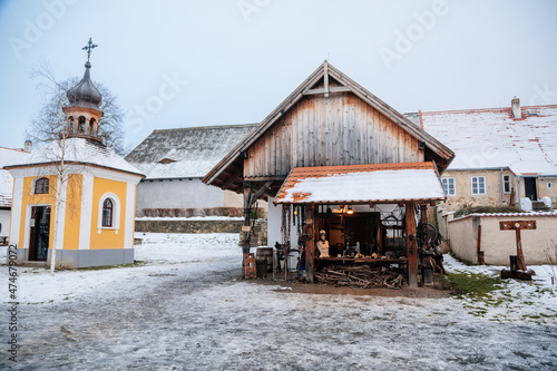 Prerov nad Labem, Czech Republic, 5 December 2021: Forged products, blacksmith shop, chains, Traditional historic country-style architecture in Skanzen, Polabi open-air ethnographic museum in winter photo