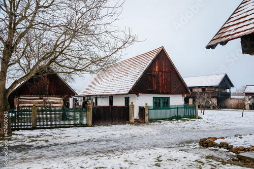 Prerov nad Labem, Czech Republic, 5 December 2021: Traditional village wooden farm house in winter, historic country-style architecture, Christmas in Skanzen, Polabi open-air ethnographic museum photo