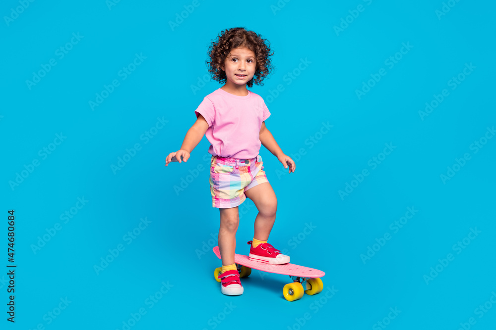 Full length body size view of attractive cheery girl riding skate having fun isolated over bright blue color background Full length body size view of attractive cheery girl riding skate having fun isolated over bright blue color background