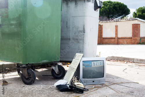 Bild auf Leinwand Televisión de tubo antigua y otros aparatos electrónicos, como un teclado viejo, junto a dos contenedores de basura