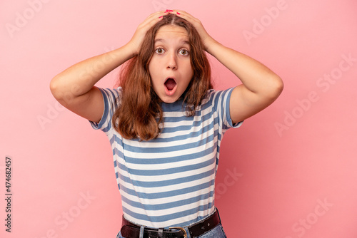 Little caucasian girl isolated on pink background surprised and shocked.