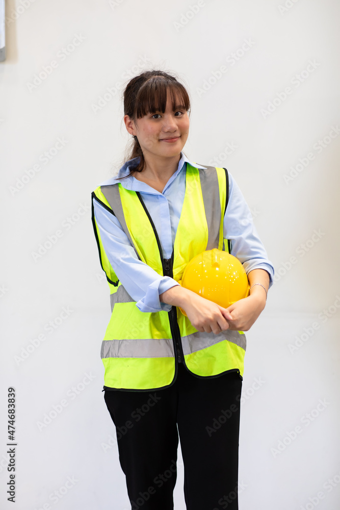 Portrait of young asian woman worker wearing safety vest and hardhat helmet workingin warehouse. logistic and business import export. Portrait of young asian woman worker wearing safety vest and hardhat helmet workingin warehouse. logistic and business import export.