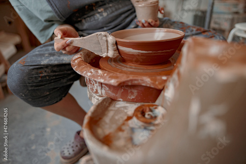 Female potter master working on craft in clay studio