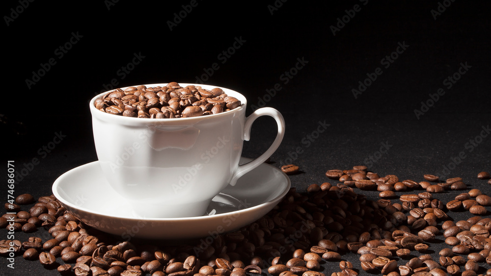 Cup of aromatic coffee with coffee beans on a dark background Cup of aromatic coffee with coffee beans on a dark background