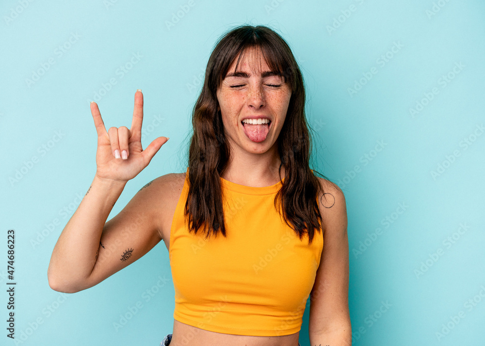 Fototapeta premium Young Argentinian woman isolated on blue background showing rock gesture with fingers