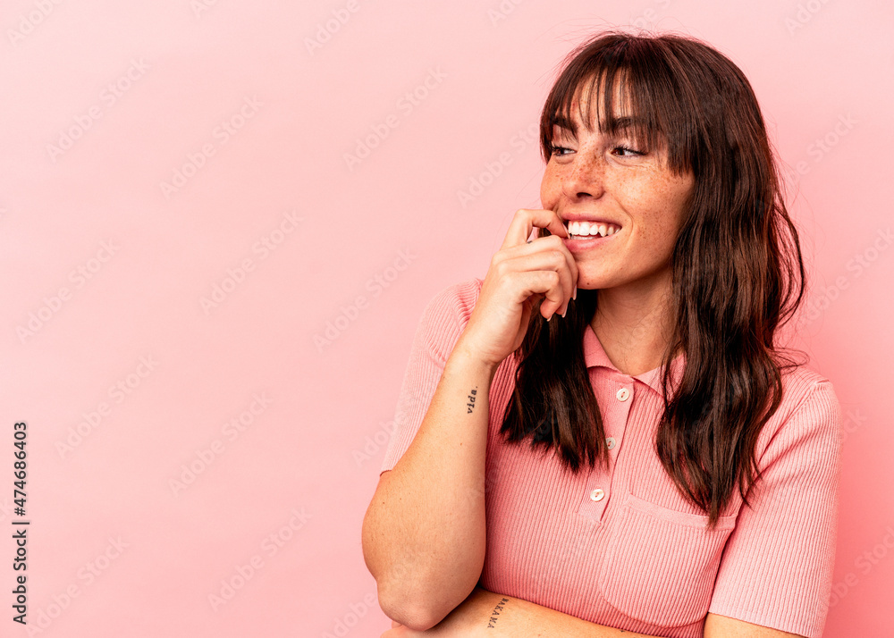 Young Argentinian woman isolated on pink background relaxed thinking about something looking at a copy space. Young Argentinian woman isolated on pink background relaxed thinking about something looking at a copy space.