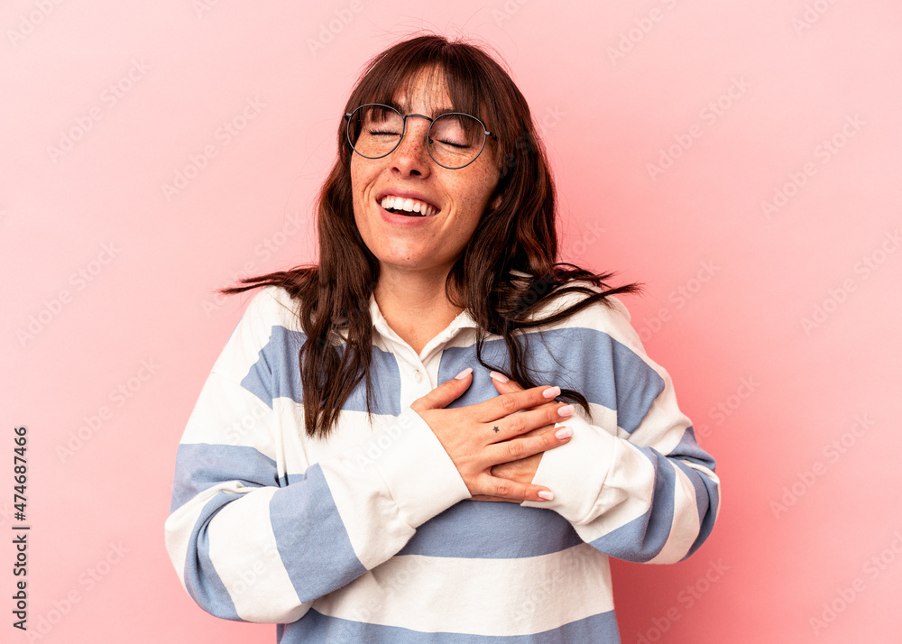 Young Argentinian woman isolated on pink background has friendly expression, pressing palm to chest. Love concept. Young Argentinian woman isolated on pink background has friendly expression, pressing palm to chest. Love concept.