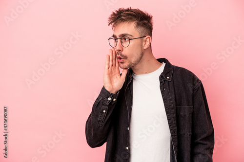 Young caucasian man isolated on pink background being shocked because of something she has seen. © Asier