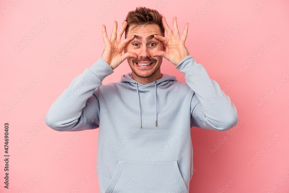 Young caucasian man isolated on pink background keeping eyes opened to find a success opportunity. Young caucasian man isolated on pink background keeping eyes opened to find a success opportunity.